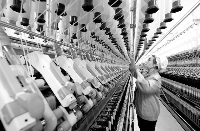 图为山东省枣庄市一家纺织企业工人在车间生产细纱产品.孙中喆 摄
